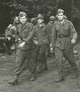 Deutsche Soldaten gehen unter Bewachung englischer Fallschirmjäger in Gefangenschaft