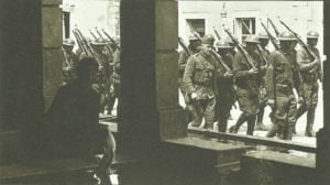 Amerikanische Soldaten marschieren durch eine französische Ortschaft 
