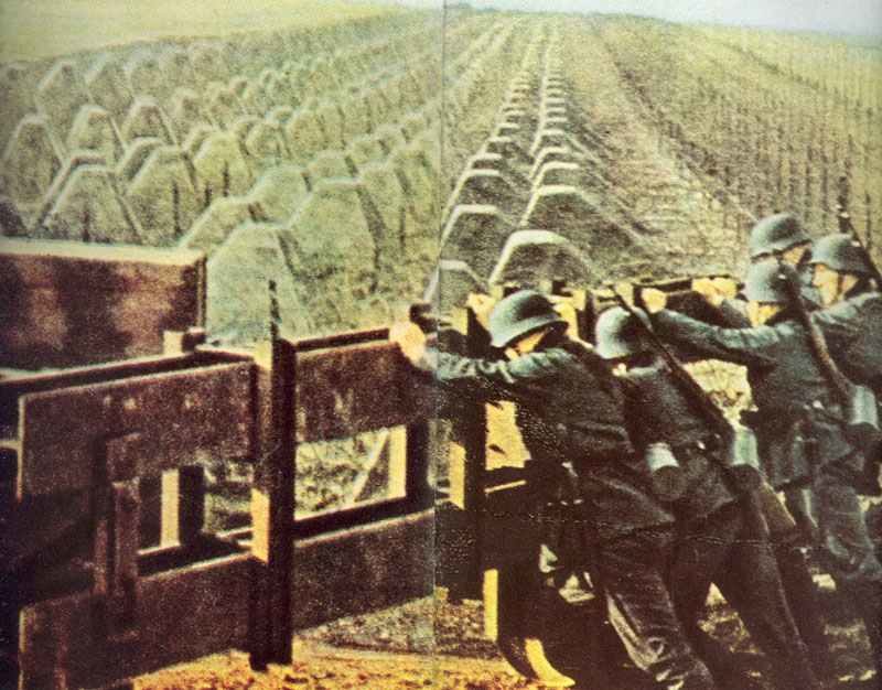 Deutsche Soldaten schließen das Tor an einer Panzersperre aus Betonklötzen am Westwall