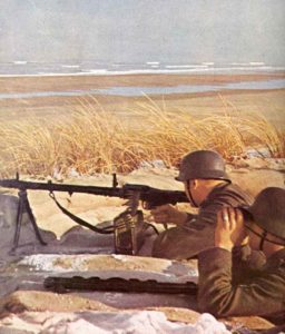 Soldaten bewachen mit ihrem MG34 einen Strand an der Kanal-Küste.