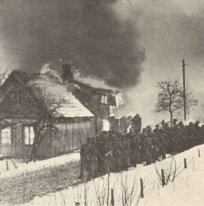 Deutsche Truppen in einem brennenden norwegischen Dorf. 