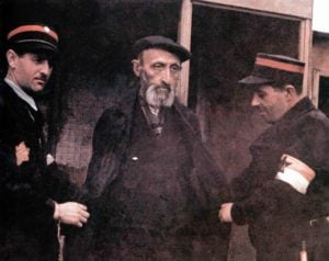 Jude wird von zwei Mitgliedern der jüdischen Ghettopolizei von Lodz festgenommen