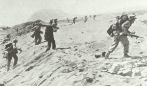 Marine schleppt Browning-MG über Strand von Iwo Jima
