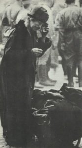 alte Frau mit dem Rest ihrer Habe nach dem Luftangriff